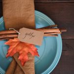 A blue plate with cinnamon sticks on it. The sticks have a note attached that reads "Gather"