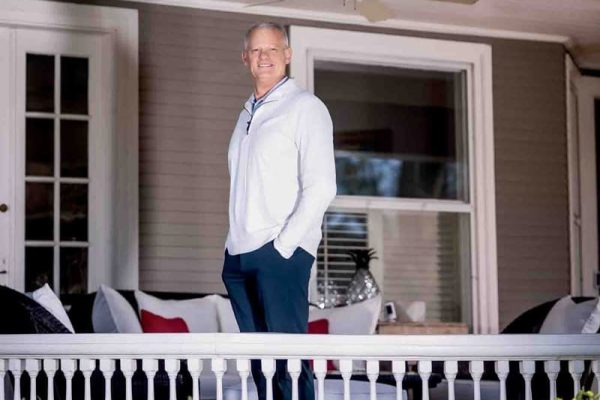 Phil andrew poses on a porch.