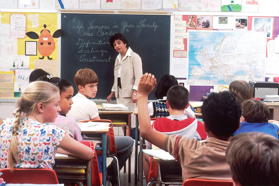 Education Child raises his hand in a classroom.