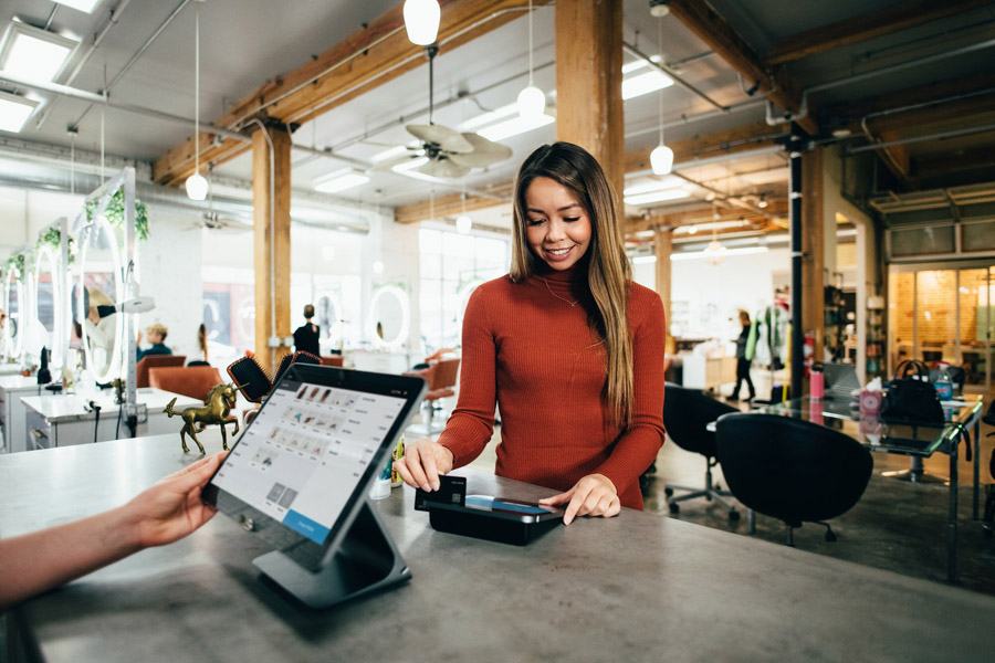 Hospitality Woman pays for something in an office space.